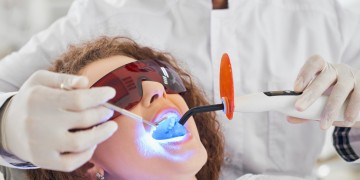 Patientin wird mit einem Intraoralscanner behandelt